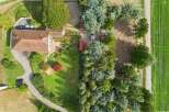 Discover this charming property featuring a spacious house with a red-tiled roof, surrounded by lush greenery and mature trees.