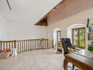 Discover a charming loft space featuring a cozy reading nook with a telescope and a dedicated workspace.