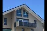 Discover modern living in this stunning home featuring a sleek balcony perfect for enjoying the outdoors.