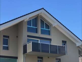 Discover modern living in this stunning home featuring a sleek balcony perfect for enjoying the outdoors.