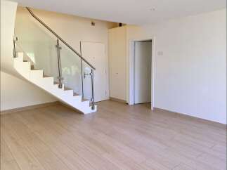 Step into this bright and airy home featuring a modern staircase with glass railings and sleek stainless steel accents.