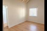 Discover this bright and airy room featuring a vaulted ceiling with exposed beams, creating a sense of spaciousness.