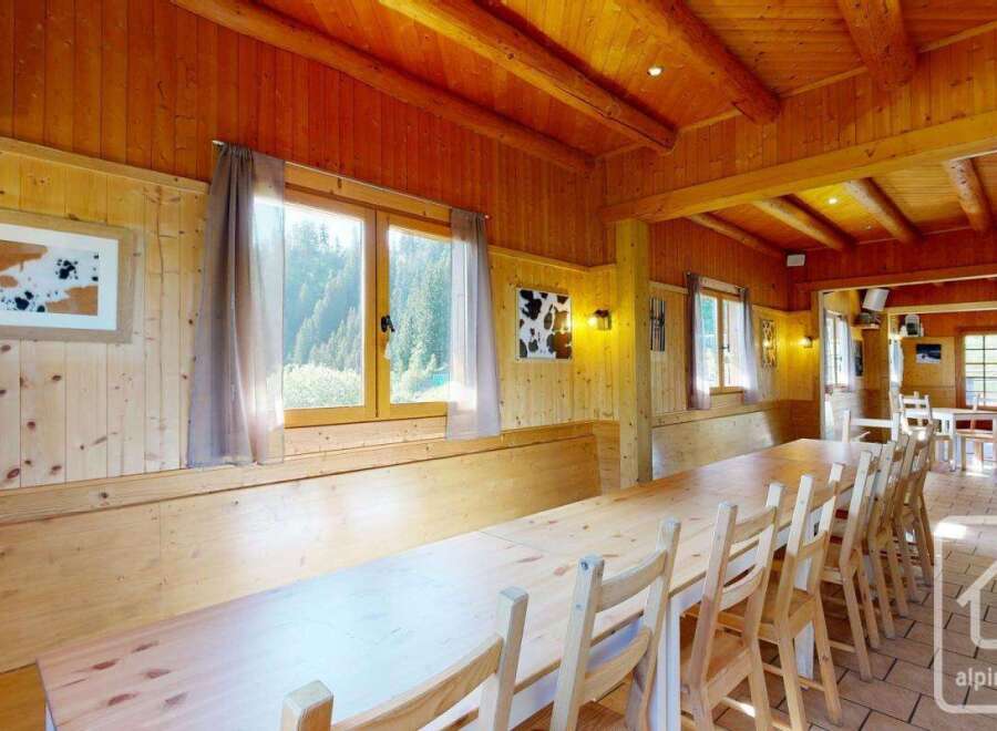 Experience rustic charm in this wood-paneled dining area, featuring a long, communal wooden table perfect for gathering.