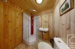 Experience rustic charm in this bathroom, featuring warm wooden paneling on the walls and ceiling.