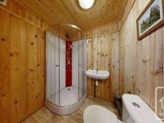 Experience rustic charm in this bathroom, featuring warm wooden paneling on the walls and ceiling.