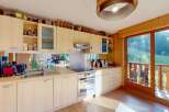Experience the charm of this well-appointed kitchen, featuring light wood cabinetry and a sleek stainless steel backsplash.
