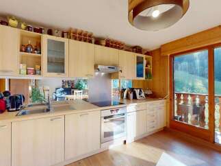 Experience the charm of this well-appointed kitchen, featuring light wood cabinetry and a sleek stainless steel backsplash.