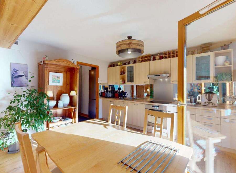 This charming kitchen boasts a rustic wooden beam overhead, adding character and warmth to the space.