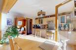 This charming kitchen boasts a rustic wooden beam overhead, adding character and warmth to the space.