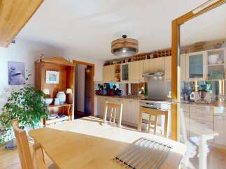 This charming kitchen boasts a rustic wooden beam overhead, adding character and warmth to the space.