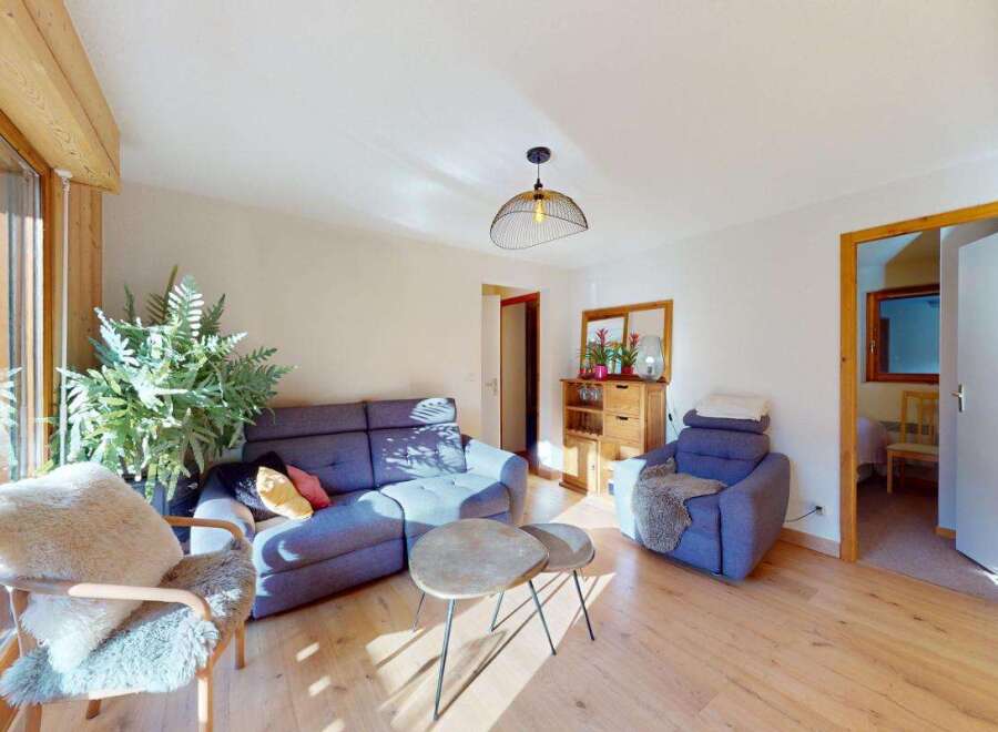 This inviting living room features a comfortable blue sectional sofa and a plush armchair, perfect for relaxing.
