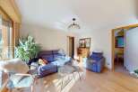 This inviting living room features a comfortable blue sectional sofa and a plush armchair, perfect for relaxing.