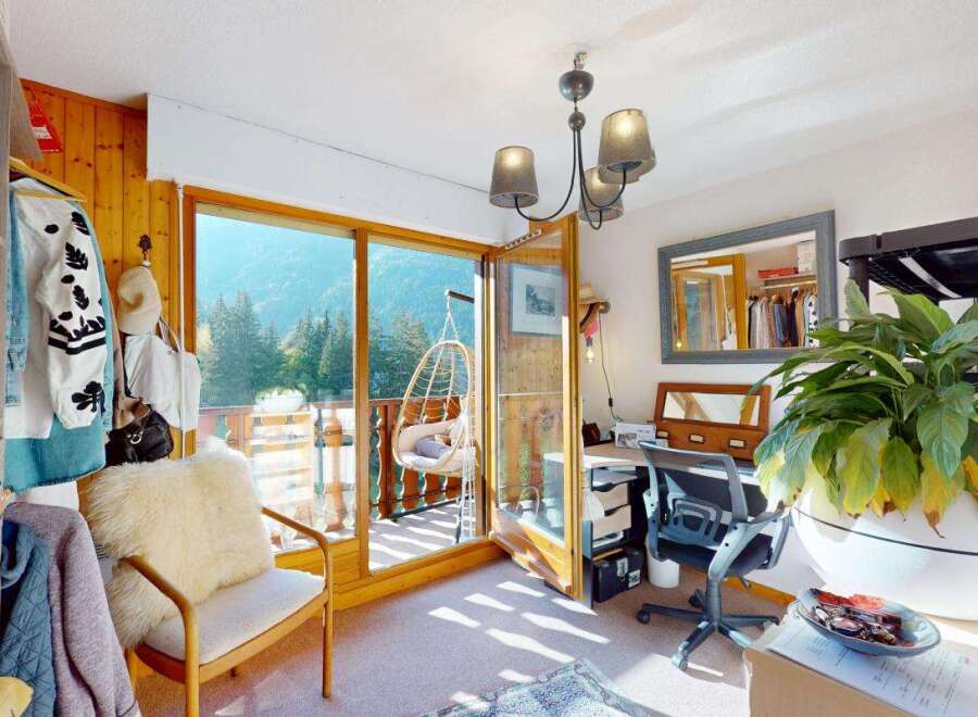 Experience breathtaking mountain views from this charming room, complete with a cozy armchair and a unique hanging chair on the balcony.