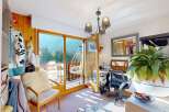 Experience breathtaking mountain views from this charming room, complete with a cozy armchair and a unique hanging chair on the balcony.