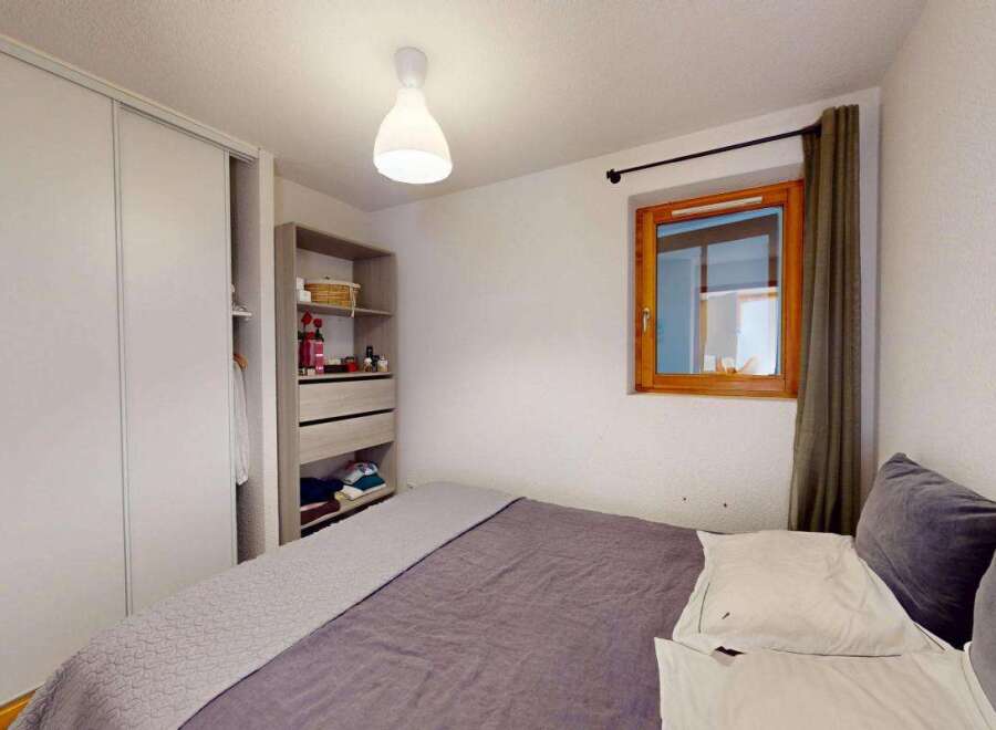 This cozy bedroom features a spacious sliding door wardrobe, perfect for ample storage.