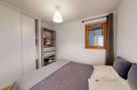 This cozy bedroom features a spacious sliding door wardrobe, perfect for ample storage.
