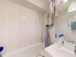 This bathroom features a clean and functional design with tiled walls and a bathtub.