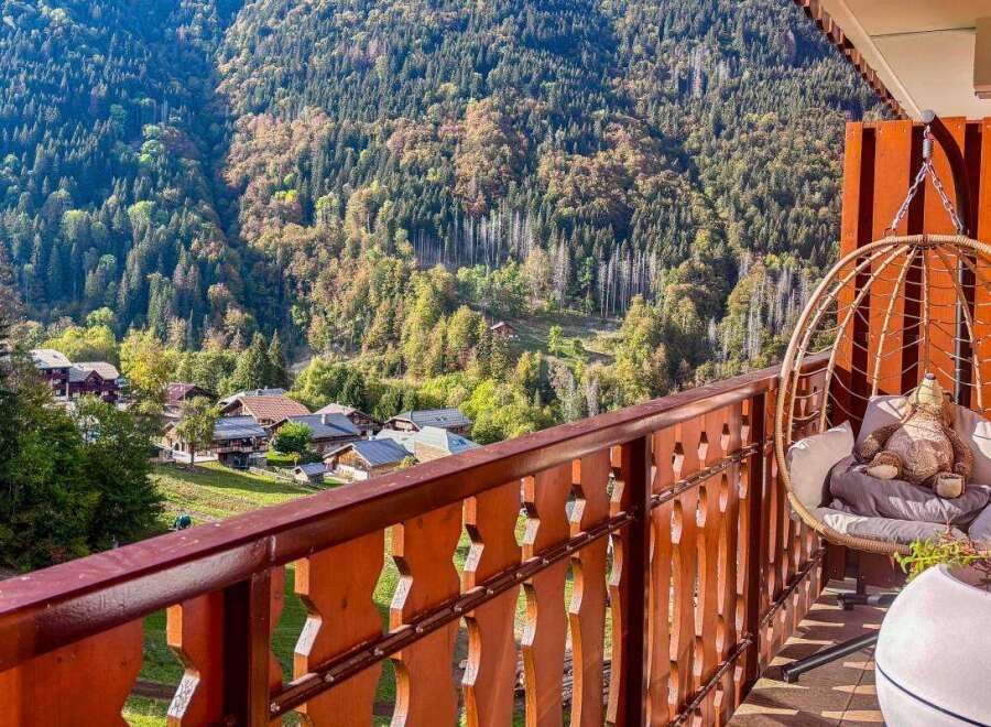 Experience breathtaking mountain views from this charming balcony, complete with a cozy hanging chair perfect for relaxation.