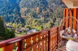 Experience breathtaking mountain views from this charming balcony, complete with a cozy hanging chair perfect for relaxation.
