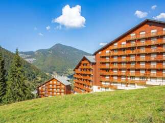 Experience the charm of mountain living in this stunning property, featuring a classic wooden facade and multiple balconies offering breathtaking views.
