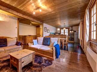 Experience rustic charm in this inviting living space, featuring warm wooden beams and a cozy seating area perfect for relaxation.