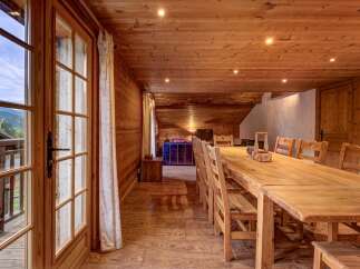 Experience rustic charm in this beautifully appointed dining room, featuring a long, natural wood table perfect for gatherings.