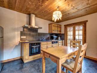 Experience rustic charm in this cozy kitchen, featuring warm wooden cabinetry and a charming dining area perfect for intimate meals.