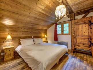 Experience rustic charm in this cozy bedroom, featuring a comfortable queen-size bed dressed in crisp white linens.