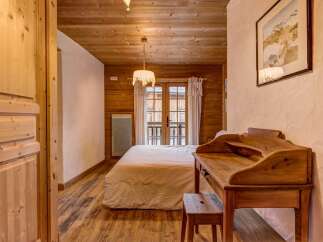 Experience rustic charm in this cozy bedroom, featuring warm wooden walls and ceiling, and a comfortable bed.