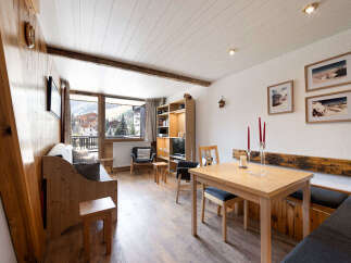 Experience cozy mountain living in this charming apartment, featuring a rustic wooden interior and stunning views of the Alps from the balcony.