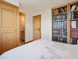 This charming bedroom features a cozy bed with a nature-inspired duvet cover, perfect for a restful night's sleep.