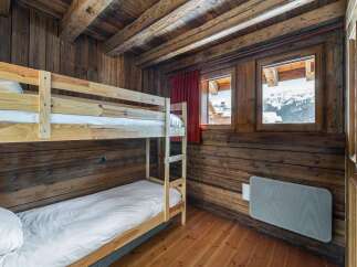 Experience cozy mountain living in this charming wooden cabin bedroom, featuring a space-saving bunk bed perfect for families or groups.