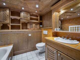 Experience rustic charm in this beautifully appointed bathroom, featuring warm wooden paneling and a coffered ceiling.