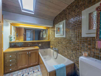 This charming bathroom features a warm wooden vanity with ample storage, complemented by a classic bathtub perfect for relaxation.