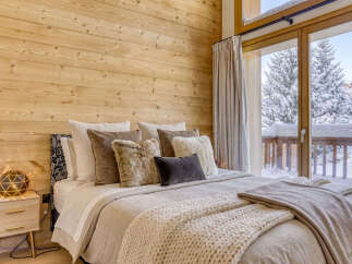 Experience cozy mountain living in this charming bedroom, featuring a comfortable bed adorned with plush pillows and a chunky knit throw.