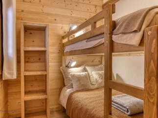 Experience cozy living in this charming wooden cabin bedroom, featuring a sturdy bunk bed perfect for families or guests.