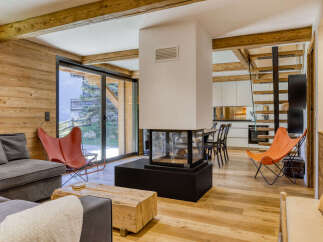 Experience luxurious mountain living in this stunning open-plan living space, featuring a modern fireplace as the centerpiece.