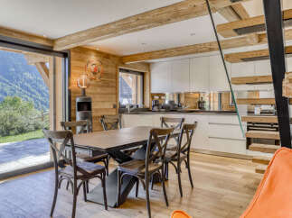 Experience modern alpine living in this stunning dining and kitchen area, featuring a sleek contemporary dining set and a fully equipped kitchen with ample cabinet space.