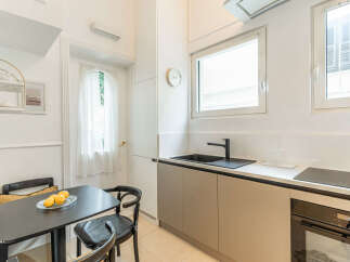This modern kitchen features a sleek design with ample counter space and a built-in oven and stovetop.