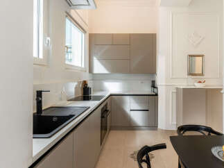 Discover this modern kitchen featuring sleek grey cabinetry and a durable quartz countertop.