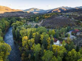 Experience the beauty of autumn in this stunning aerial view of a property nestled amongst vibrant fall foliage.