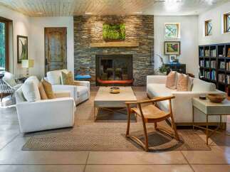 Experience rustic elegance in this inviting living room, featuring a striking stacked stone fireplace as the centerpiece.