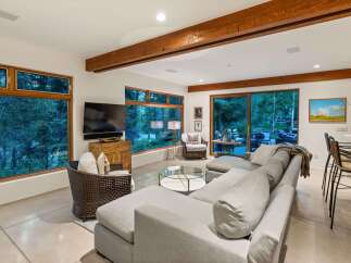 Experience luxurious living with this stunning living room featuring a large sectional sofa, a cozy armchair, and a glass coffee table.