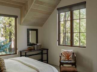 This bedroom features a unique sloped ceiling with exposed wooden beams, creating a cozy and rustic ambiance.