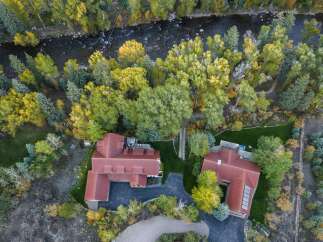 Experience luxury living with this stunning aerial view of a multi-level home nestled amongst vibrant autumn foliage.