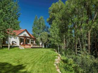 Experience luxurious outdoor living with this stunning property featuring a spacious deck, a relaxing hot tub, and a built-in grill, perfect for entertaining guests.