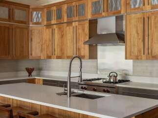 This modern kitchen boasts custom wood cabinetry with sleek metal accents, offering ample storage and a sophisticated aesthetic.