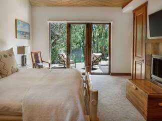 Experience serene living in this beautifully appointed bedroom, featuring a cozy bed with plush linens and decorative pillows.