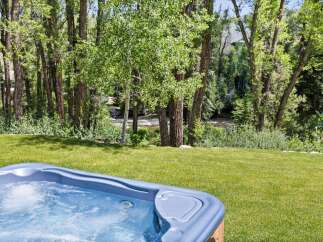 Indulge in ultimate relaxation with this luxurious hot tub, perfectly situated on a lush green lawn.