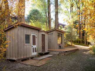 Nestled amongst vibrant autumn foliage, these charming wooden cabins offer a rustic retreat.